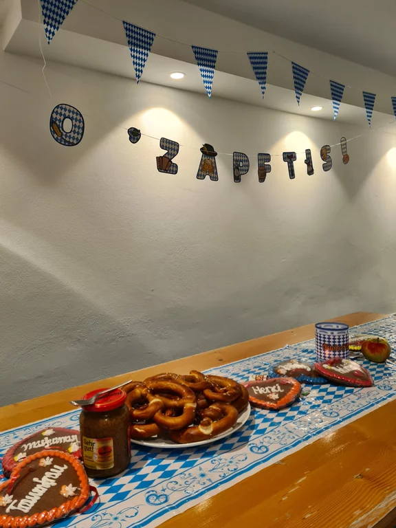Tisch mit bayerischen Spezialitäten und Banner O Zapft is
